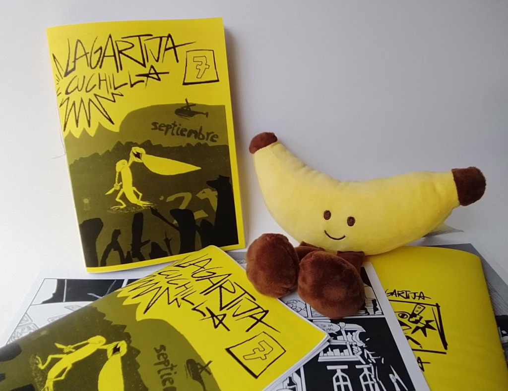 Fotografía del séptimo número, en él, aparece  un platano sentado encima de un puñado de fanzines de este número, son de color amarillo. A la derecha se puede ver el fanzine de forma frontal.