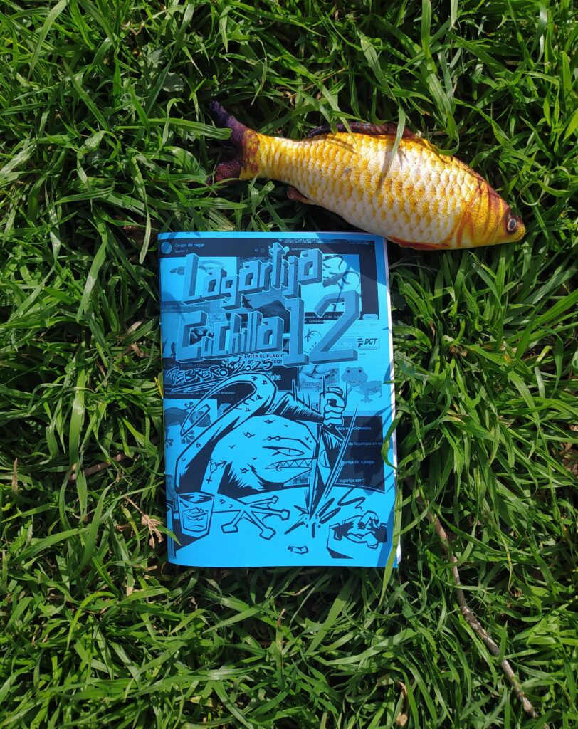 Fotografía de lanzamiento del número doce. en el vemos el fanzine en el centro de la imagen de color azul, un pez decorativo y el fondo es un cesped.