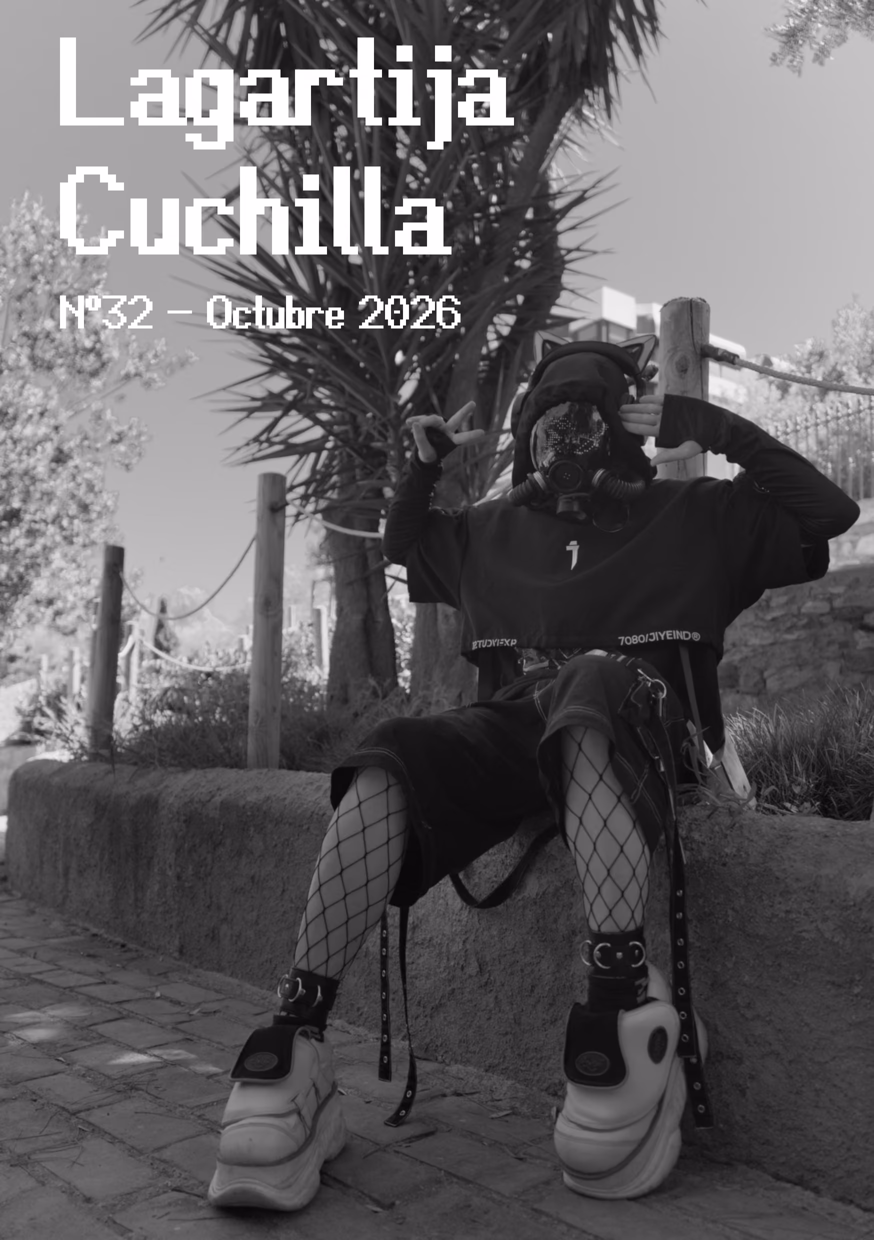 Portada del trigésimo segundo número, es una fotografía a contraluz donde sale una persona sentada en un parque con una mascara de gas, cascos con orejas de gato, unos zapatos muy altos y grandes y mallas saludando con el símbolo de la paz en su mano derecha y un saludo militar en la mano izquierda. En la mascara de gas tiene unos patrones iluminados por LED, donde se puede ver el logo de Lagartija Cuchilla, que es una lagartija con la boca abierta atravesada por un cuchillo.