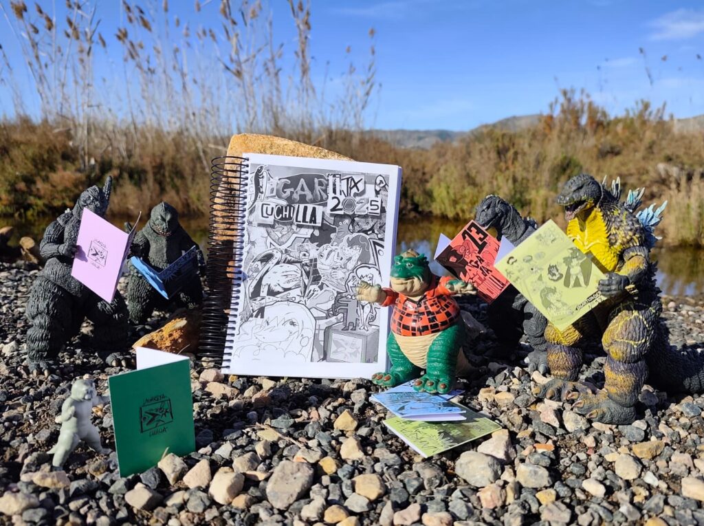 Muchos muñecos de acción de Godzilla, una lagartija, y Minilla leyendo fanzines de Lagartija Cuchilla en el bosque.